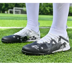 Detailed side view of high-top soccer cleats on artificial turf with white socks