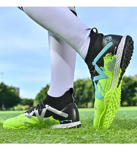 Detail of kids' high-top soccer shoes with AG/TF studs in neon green and black