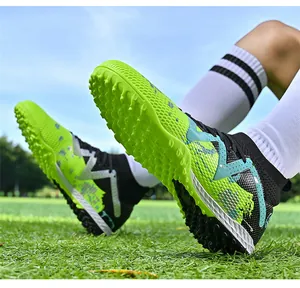 Close-up detail of professional fluorescent green soccer shoes with TF cleats on grass