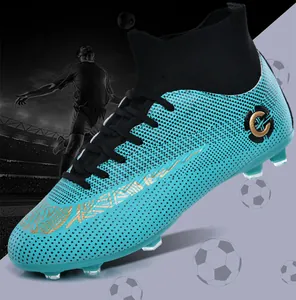 Side view of cyan high-top soccer cleats with firm ground studs in a stadium setting
