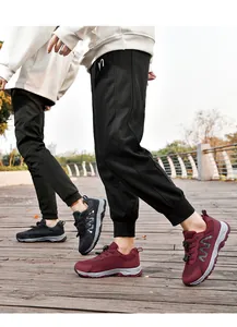 Detailed shot of lightweight mesh walking shoes on an outdoor wooden walkway in the park.
