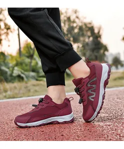 Close-up of burgundy mesh walking shoes with adjustable drawcord on a running track