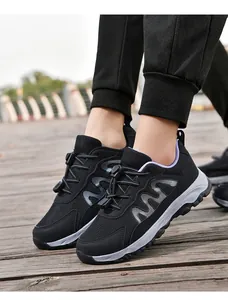 Close-up of black breathable mesh walking shoes with toggle laces on wooden deck