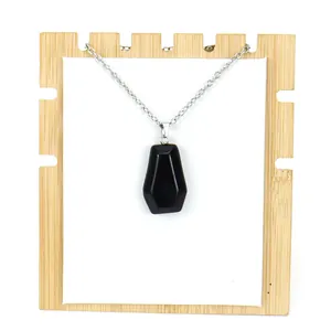 Macro detail view of a black natural crystal stone coffin pendant necklace for Halloween