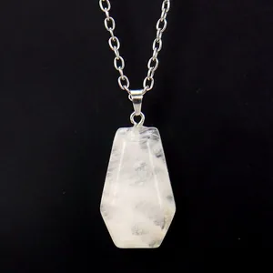 Macro view of a natural white crystal pendant in a miniature coffin shape with silver chain