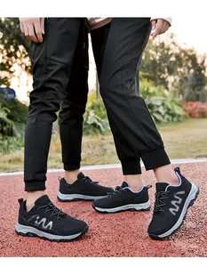Detailed view of breathable black mesh walking shoes worn on an outdoor running track