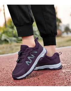 Detailed view of purple mesh walking shoes worn on an outdoor track for exercise