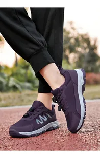 Detail view of purple breathable mesh walking shoes on an outdoor running track