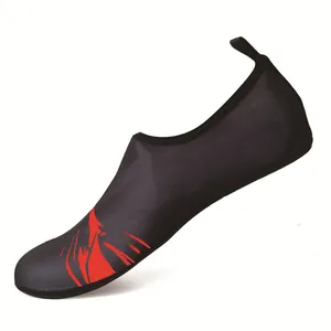 Close-up detail of black elastic mesh swimming shoes featuring a vibrant red flame graphic