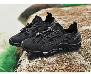 Vue détaillée des chaussures de randonnée noires respirantes sur un rocher rude