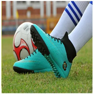 Close-up of turquoise high-top turf soccer shoes for outdoor training on grass