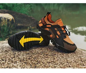 Chaussures d'eau orange respirantes avec semelle antidérapante jaune sur un rocher