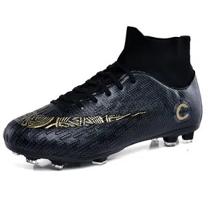 Professional high-top black soccer cleats with gold graphics and firm ground studs