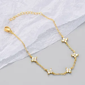Detailed macro view of elegant gold-plated bracelet with five cubic zirconia flowers