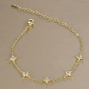 Close-up of elegant gold-plated bracelet with shimmering zircon flower charms