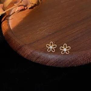 Detaillierte Nahaufnahme von Mini 14K vergoldeten Blumen-Ohrsteckern mit einem Zirkonia-Zentrum
