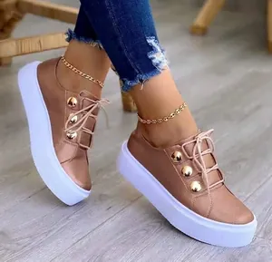 Κομψά μεταλλικά χρυσά ροζ sneakers πλατφόρμα με χοντρή σόλα και διακοσμητικά χρυσά κουμπιά.