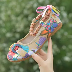 Detailed view showing the vibrant floral embroidery and bead strap on ethnic flats