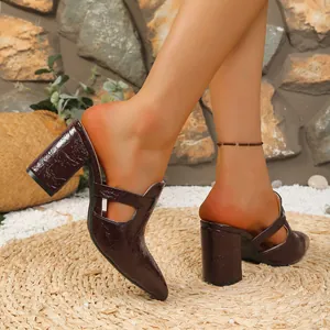 Elegante Mules mit spitzer Zehenpartie und Blockabsatz in strukturierter brauner Optik.