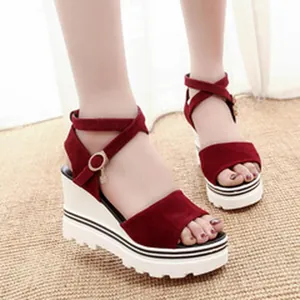 Side detail view of stylish red suede wedge sandals featuring a thick white platform sole.