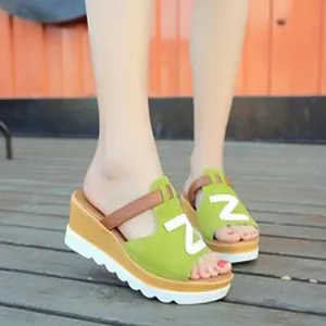 Close-up of green women's wedge platform sandals with a stylish thick white sole.