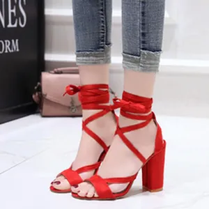 Elegant red suede sandals featuring lace-up ankle straps and a chunky high heel design