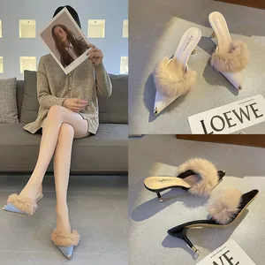 Detail view of French style pointed toe mules with elegant fur trim and kitten heels.