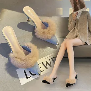 Detail view of pointed toe kitten heel mules with fluffy fur trim in blue and black