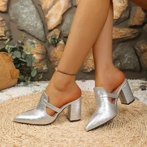 Detailansicht silberner Metallic-Mules mit spitzer Kappe, Blockabsatz und Cut-Out-Design.
