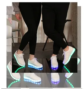 Détail de baskets blanches à LED avec des lumières de semelle vertes et bleues vives