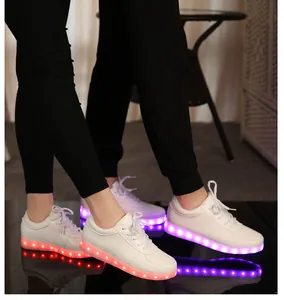 Gros plan de baskets LED blanches avec semelles lumineuses pour couples et adultes.