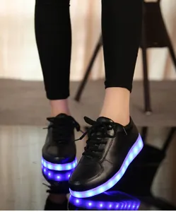 Gros plan de baskets à LED noires avec semelles lumineuses bleues