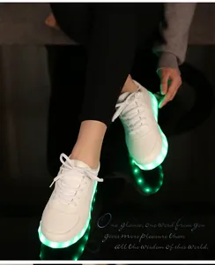 Gros plan de baskets LED blanches brillant en vert vif dans un environnement sombre