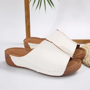 Sandali con zeppa bianchi da donna con spessa piattaforma marrone e punta aperta.