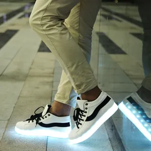Vue latérale détaillée de baskets à LED blanches avec semelles lumineuses dans le noir