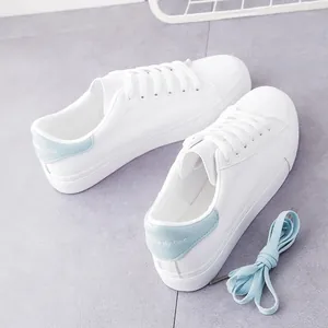 Detailansicht weißer Plateau-Sneaker mit hellblauen Fersenakzenten und Schnürsenkeln