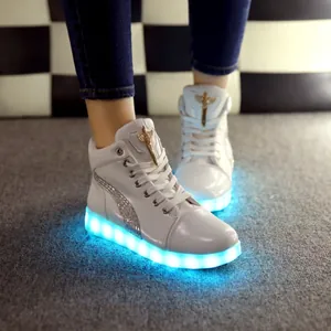 Vue rapprochée de baskets montantes blanches avec semelles LED bleues lumineuses.