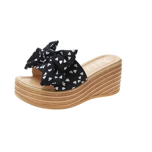 Primo piano di sandalo con zeppa da donna con fiocco a cuori e suola platform