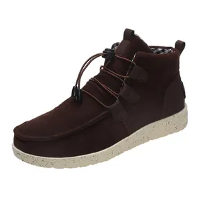 Detailed view of brown suede low-top boots with elastic laces and speckled sole