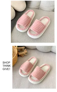 Gros plan de chaussons roses en peluche à bout ouvert avec semelle épaisse sur tissu