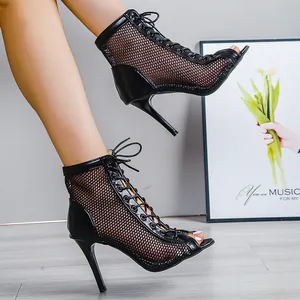 Détail de bottines à lacets en résille noire avec talons aiguilles hauts