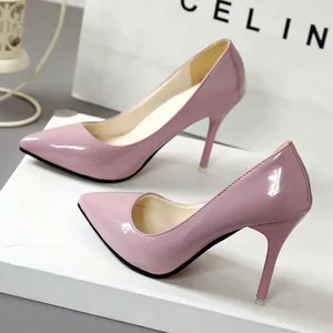 Detailed view of elegant pink patent leather pointed-toe stiletto pumps on white