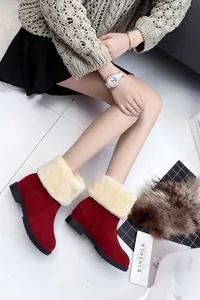 Nahaufnahme der roten Winter-Schneestiefel mit plüschigem cremefarbenem Kunstpelz.