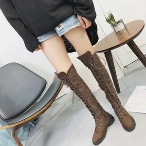 Bottes cuissardes tendance en daim marron avec lacets à l'avant et zip latéral.
