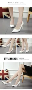 Detailed showcase of white pointed-toe high-heeled pumps in a lifestyle setting.