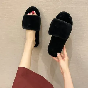 Black fluffy slippers for women, showing soft plush texture and comfortable flat design.