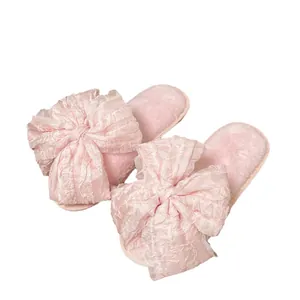 Pantofole rosa morbide con grande fiocco decorativo per un uso domestico alla moda