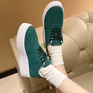 Vista laterale di sneaker platform in camoscio verde scuro con calzini a coste bianchi
