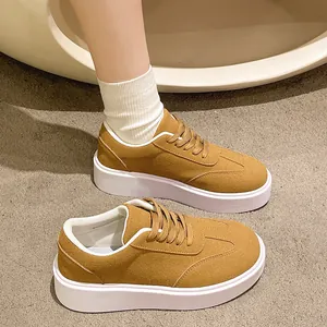 Dettaglio di sneakers platform retrò in tela giallo senape con suole bianche spesse.