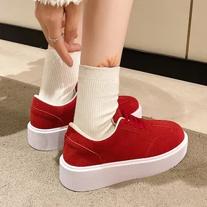 Vista dettagliata di sneaker con zeppa in pelle scamosciata rossa e suola bianca spessa